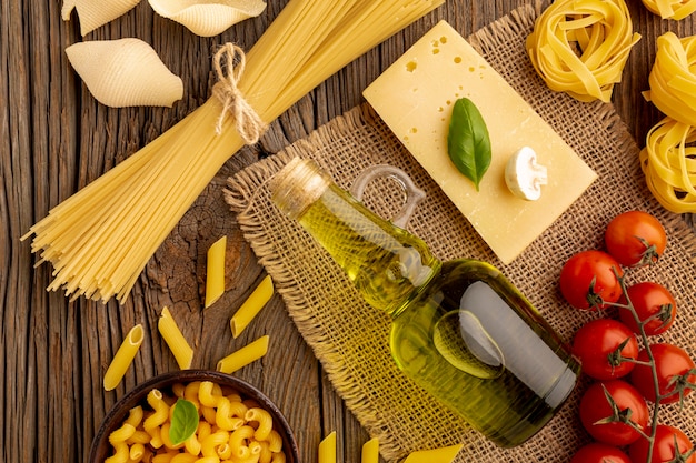 Gratis foto rauwe pasta mix met tomaten, olijfolie en harde kaas