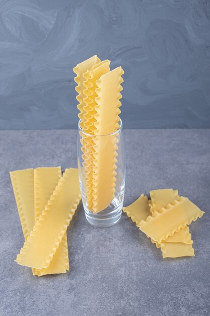 Gratis foto rauwe pasta voor het bakken van lasagne op stenen achtergrond.