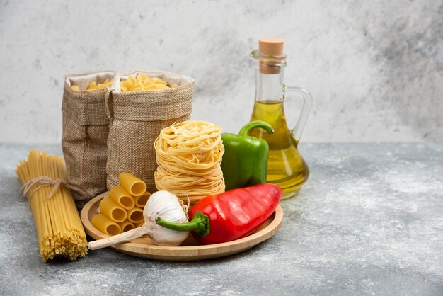 Rauwe pastasoorten met knoflook, chilipepers en olijfolie.