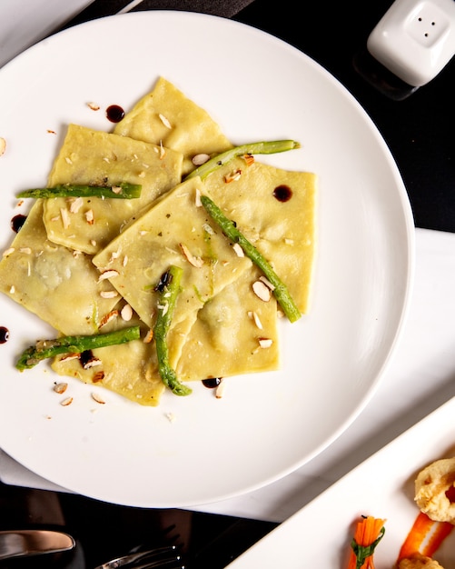 Gratis foto ravioli met asperges en geraspte noten