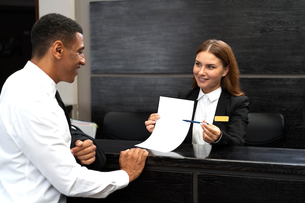 Receptioniste in elegant pak aan het werk met klant