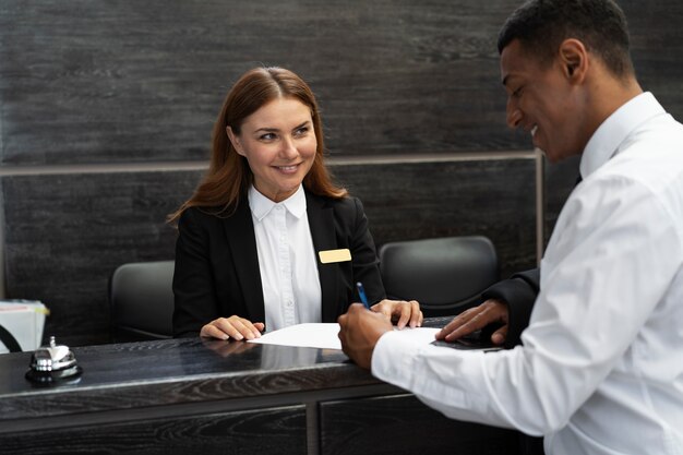 Receptioniste in elegant pak aan het werk met klant