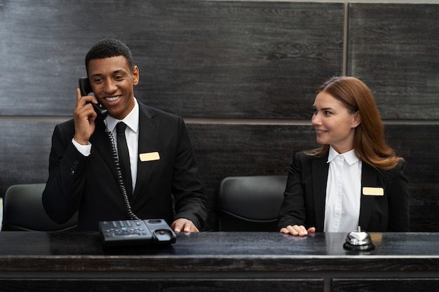 Receptionisten in elegante pakken tijdens werkuren