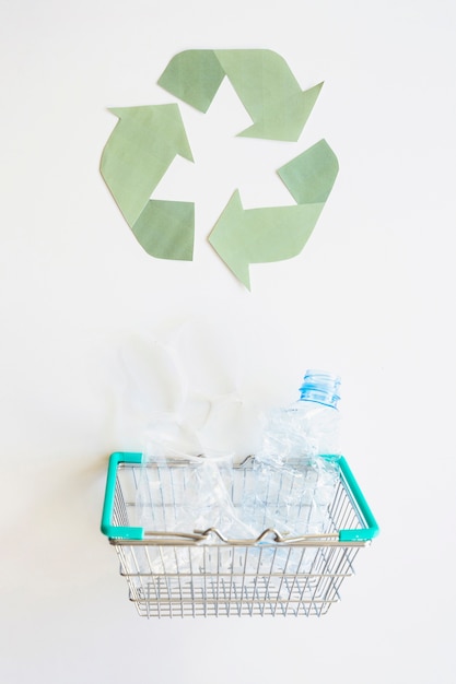 Gratis foto recycle logo en mand met plastic afval