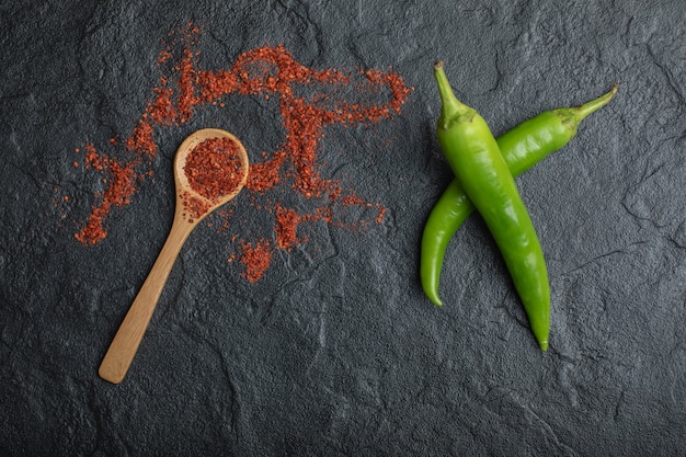 Red hot chili peper met groene verse peper op zwarte achtergrond.