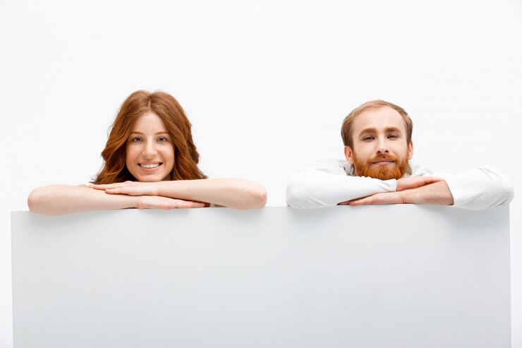 Gratis Foto redhead paar verstopt achter tafel, glimlachend