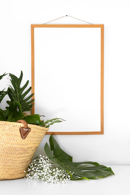 Gratis foto regeling met leeg zwart frame naast plant