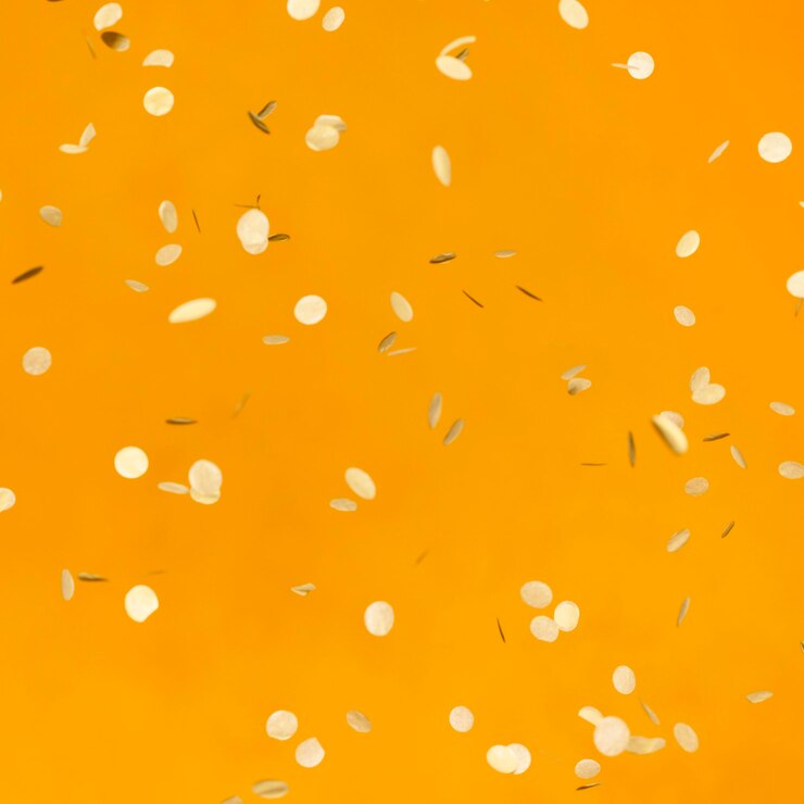 Gratis Foto regeling van gouden partijconfettien op oranje muur