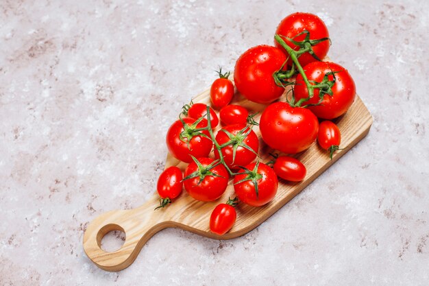 Regeling van kleurrijke verse geassorteerde tomaten op betonnen ondergrond