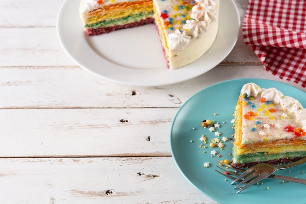 Regenbooglaagcake op witte houten tafel