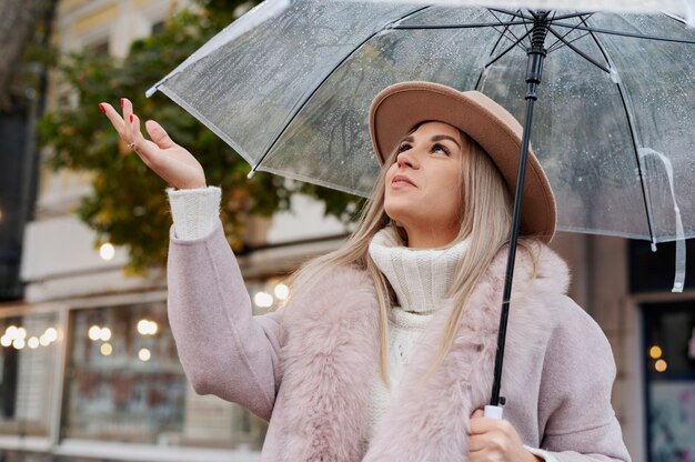 Regenportret van jonge en mooie vrouw met paraplu