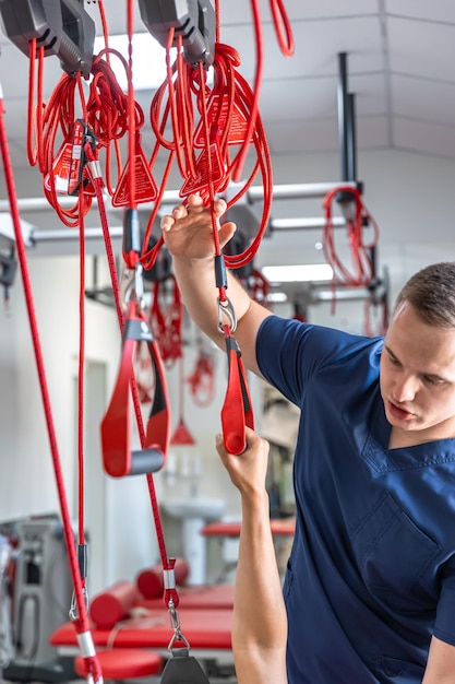 Gratis foto rehabilitatiespecialist die actieve behandeling op ophangriemen doet aan vrouwelijke patiënt