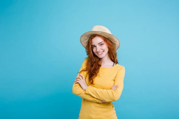 Reis concept - Close-up Portret jonge mooie aantrekkelijke roodharige meisje wtih trendy hoed en zonnebril lachend. Blauwe Pastelachtergrond. Kopieer de ruimte.