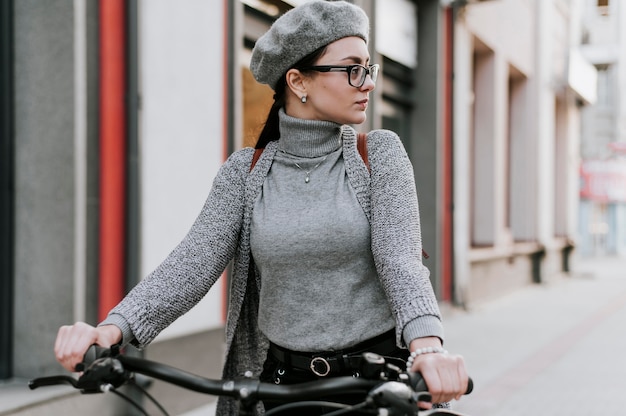 Gratis foto reis in het stadsleven met fietsvrouw wegkijkend