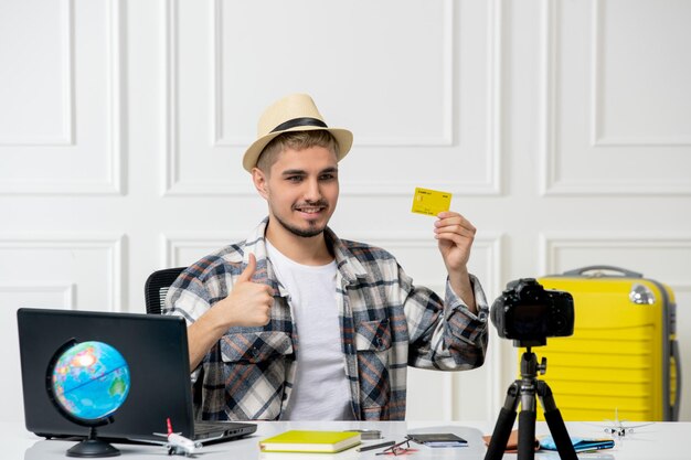Reisblogger die reisvlog opneemt op camera jonge knappe kerel in strohoed met gele kaart