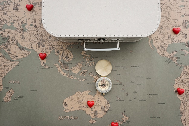 Gratis foto reizen achtergrond met kompas, koffer en wereldkaart