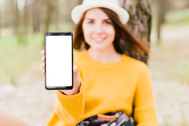 Reizende vrouw die haar telefoonscherm toont