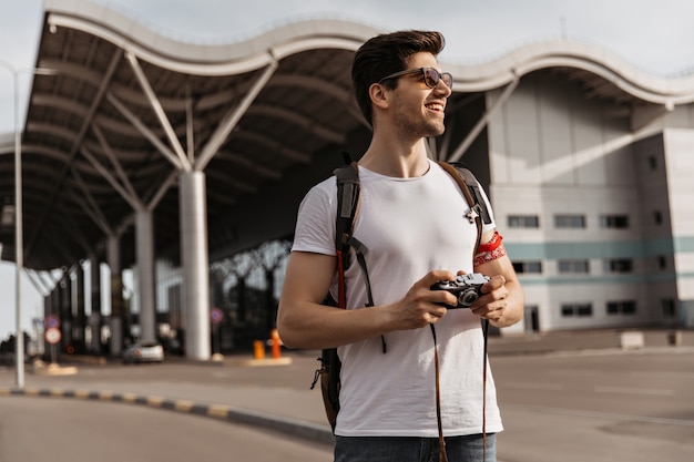 Reiziger in een goed humeur poseert in de buurt van de luchthaven