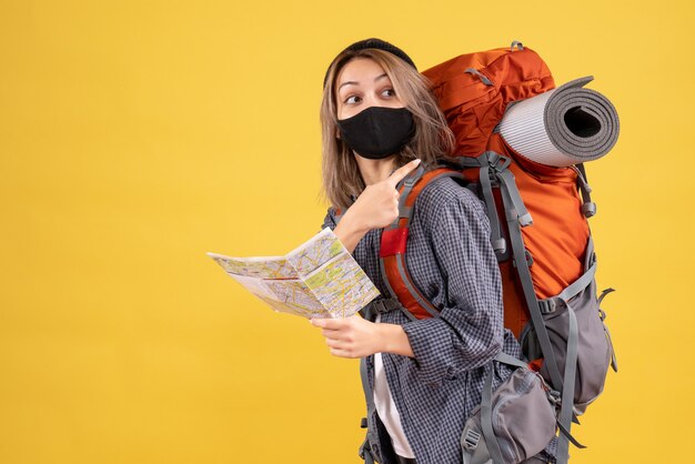 reiziger meisje met zwart masker met kaart wijzend op rugzak