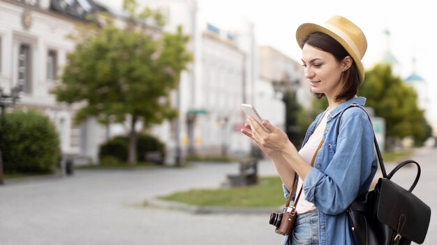 Reiziger met hoed die mobiele telefoon doorbladert