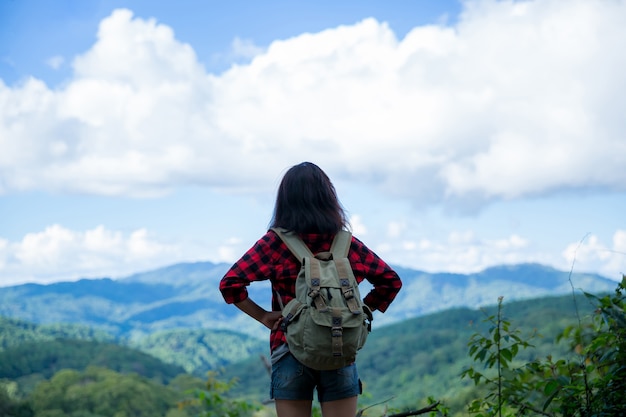 Reizigers, jonge vrouwen, kijk naar de verbazingwekkende bergen en bossen, reislustige reisideeën,