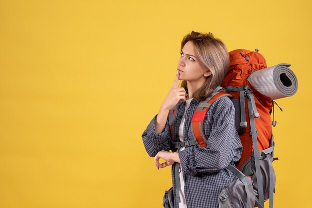 reizigersvrouw met rode rugzak die aan haar reis denkt