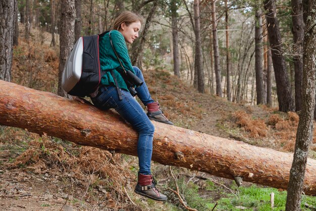 Relaxed meisje zittend op een log