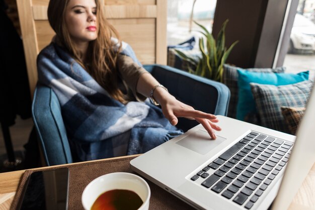 Relaxed vrouw met een hand op haar laptop