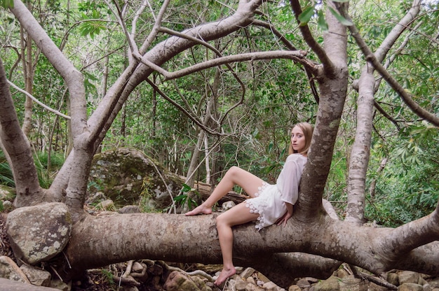 Relaxed vrouw zitten op een boomstam