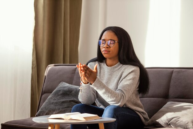 Religieuze vrouw bidden met rozenkrans kralen