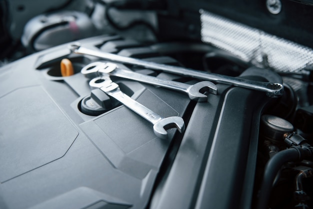 Reparatiehulpmiddelen die op de motor van auto onder de motorkap liggen