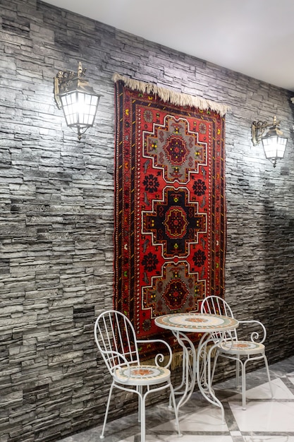 Gratis foto restaurant hal met grijze stenen muur versierd met azerbeidzjaans tapijt