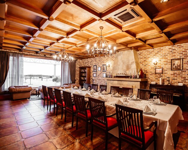 Restaurant privékamer met tafel voor 14 personen, houten plafond, bakstenen muren en open haard