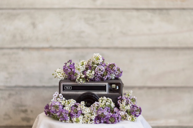 Gratis foto retro camera, omringd door paarse en witte bloemen