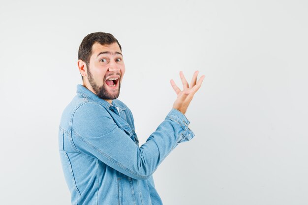 Retro-stijl man hand opsteken op een rare manier in jasje, t-shirt en op zoek naar gek.​