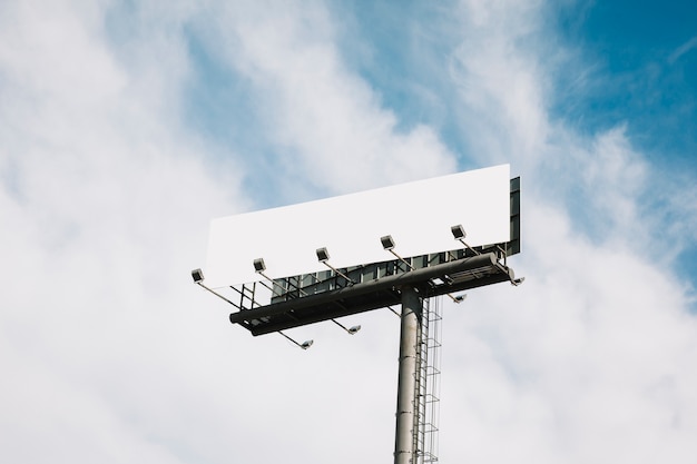 Gratis foto reusachtig kant van de wegaanplakbord op blauwe hemel