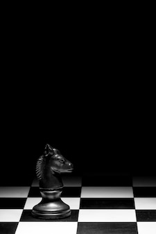 Ridder schaakstuk op het bord tegen een zwarte achtergrond
