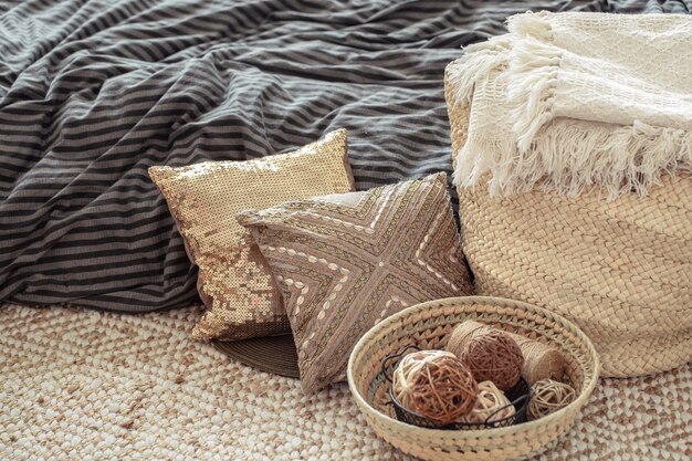 Rieten grote tas van stro, kussens en decoratieve elementen op de achtergrond van het bed.