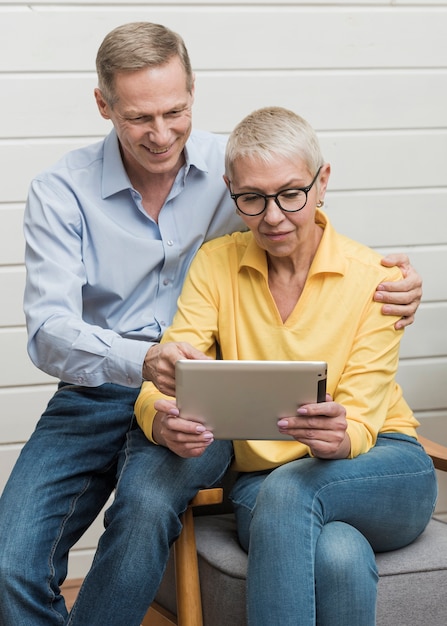 Gratis foto rijp paar dat op een tablet kijkt