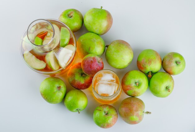 Rijpe appels met ijzige drank op wit