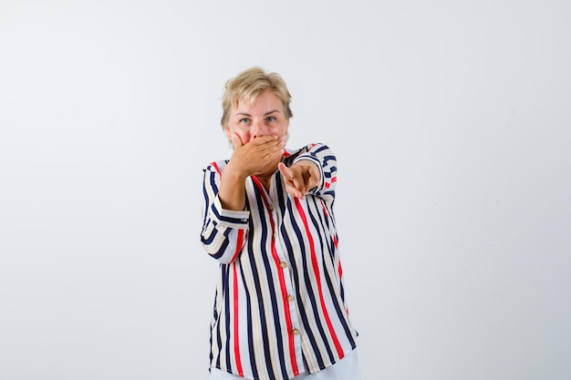 Rijpe blonde vrouw in een overhemd met verticale strepen