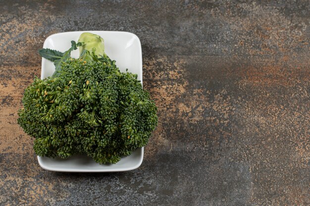 Rijpe broccoli in de kom op het marmeren oppervlak