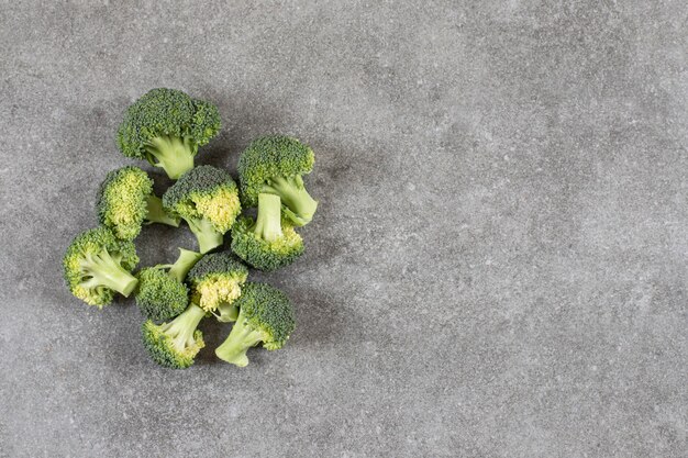 Rijpe gezonde verse broccolis geplaatst op stenen tafel.