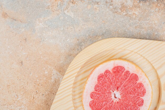 Rijpe grapefruitplak op houten plaat. Hoge kwaliteit foto