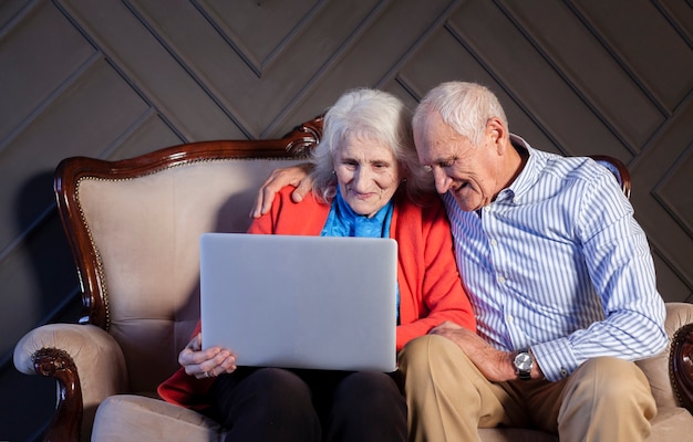 Rijpe man en vrouw die laptop met behulp van