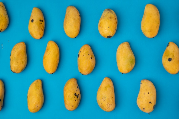 Rijpe manilla-mango gerangschikt in patronen op een blauwe achtergrond