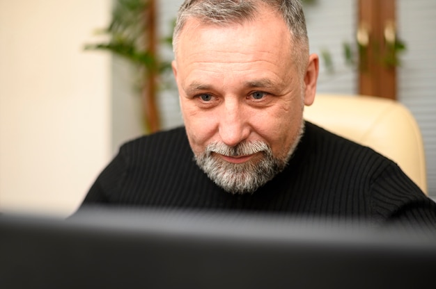 Gratis foto rijpe mens die door zijn computer kijkt