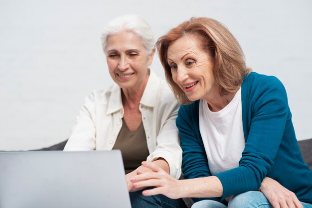 Rijpe vrouwen die op laptop doorbladeren