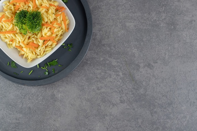 Rijst met plakjes wortel en broccoli op witte plaat. Hoge kwaliteit foto