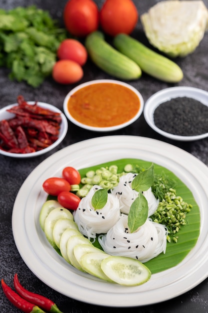 Rijstnoedels in een bananenblad met prachtig gelegde groenten en bijgerechten. thais eten.